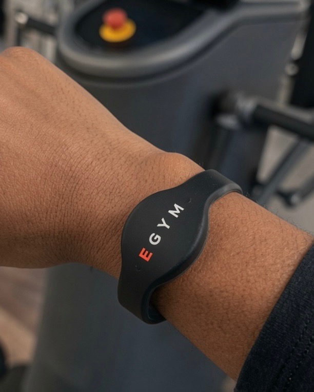 EGYM-armband buret på handleden framför en EGYM-maskin