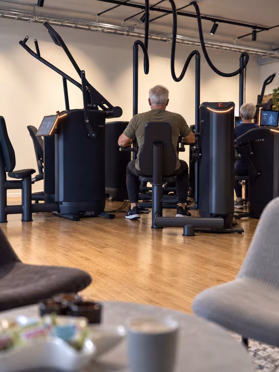 Två äldre personer sedda bakifrån vid EGYM-maskinerna i Nynäshamn